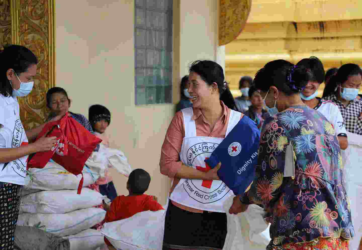 A Red Cross volunteer distributing aid packages.