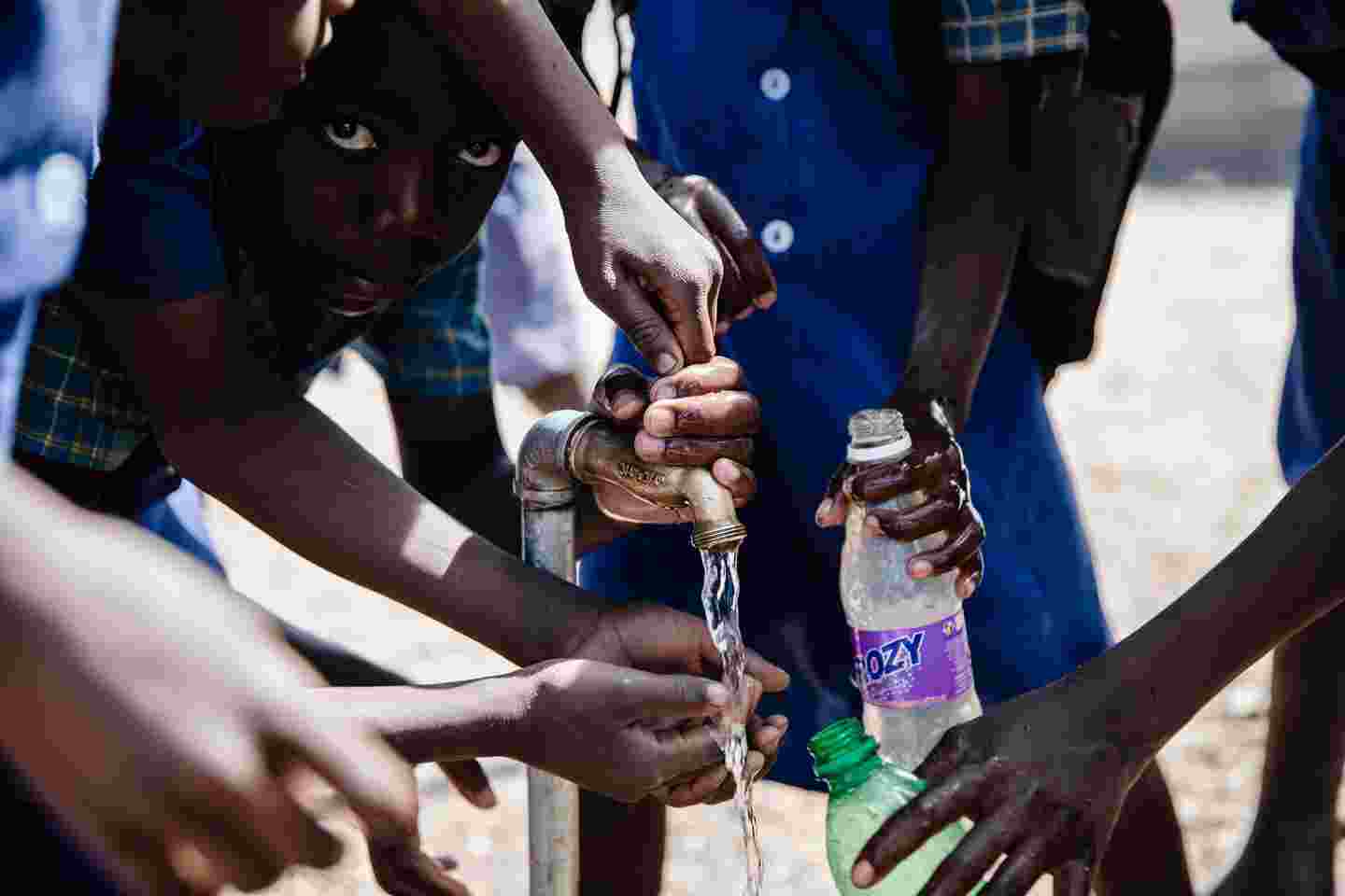 Children filling water bottles.