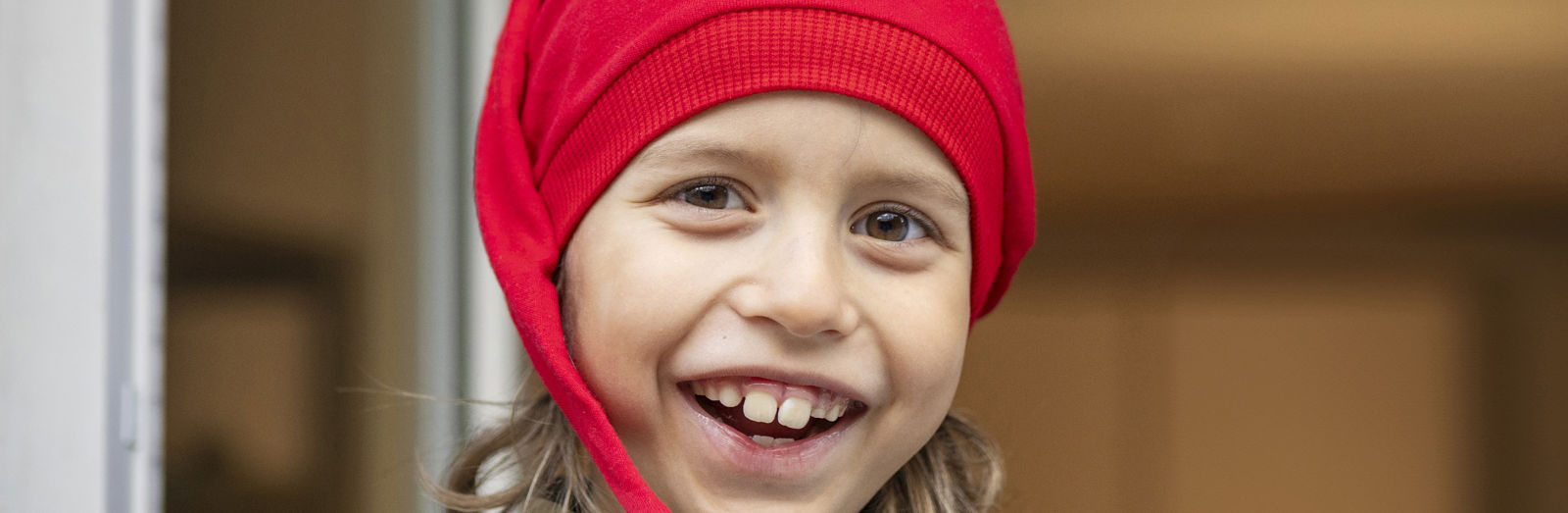 A smiling child wearing a Santa hat.