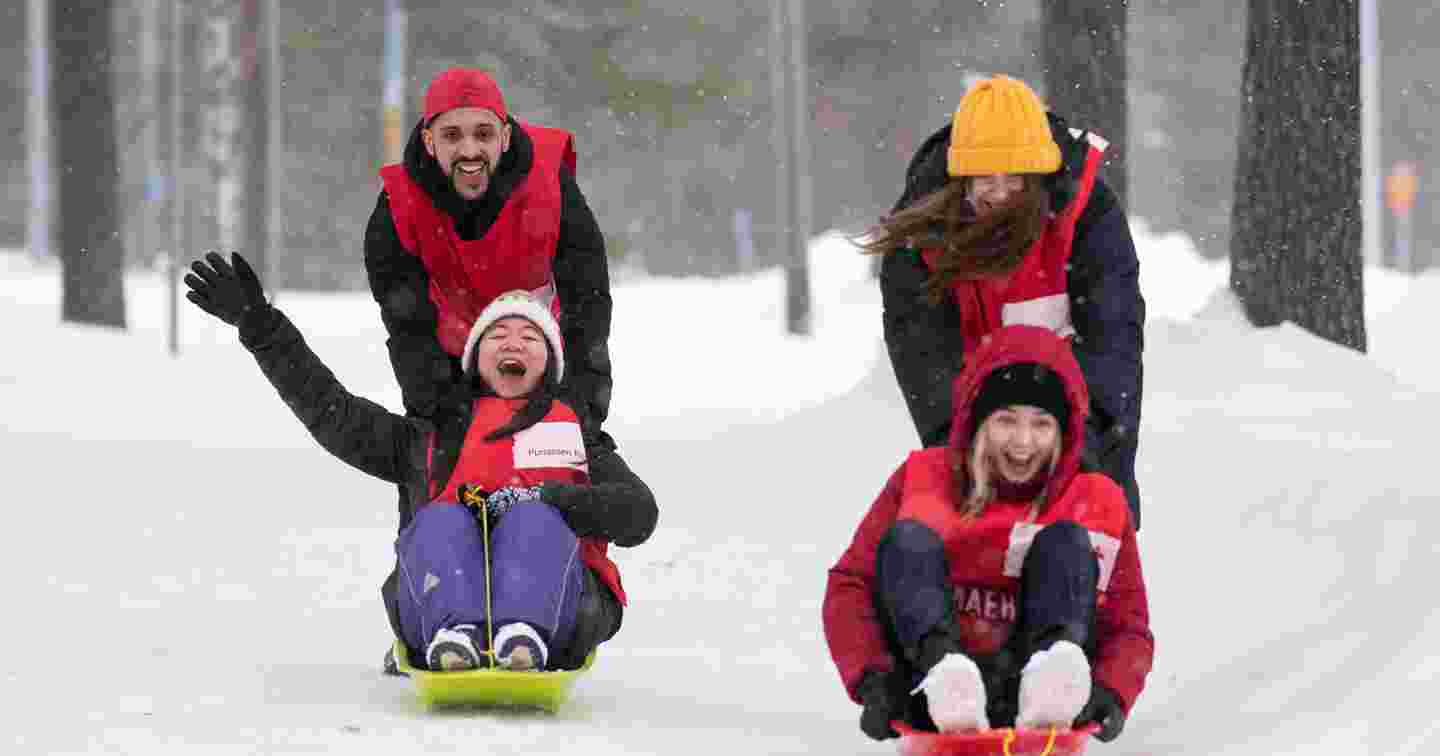 Happy Red Cross volunteers sledding.