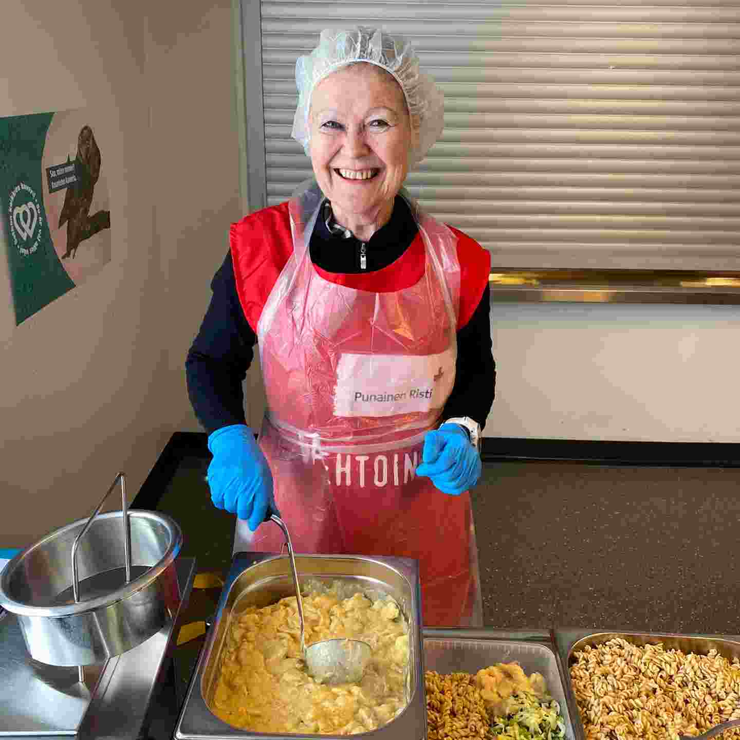 A smiling volunteer with food dishes in front of her.