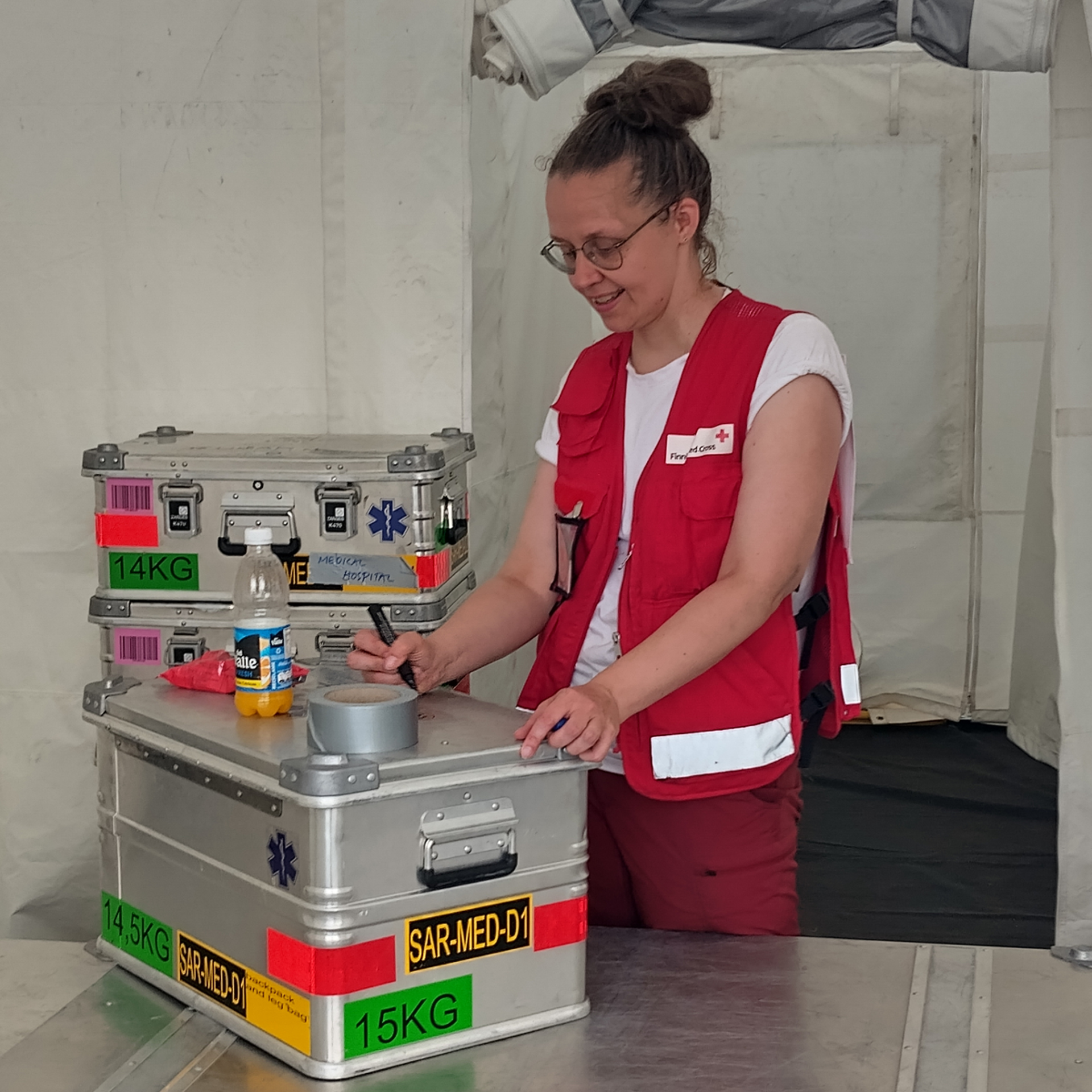 Aid worker sorting and packing medical supplies.
