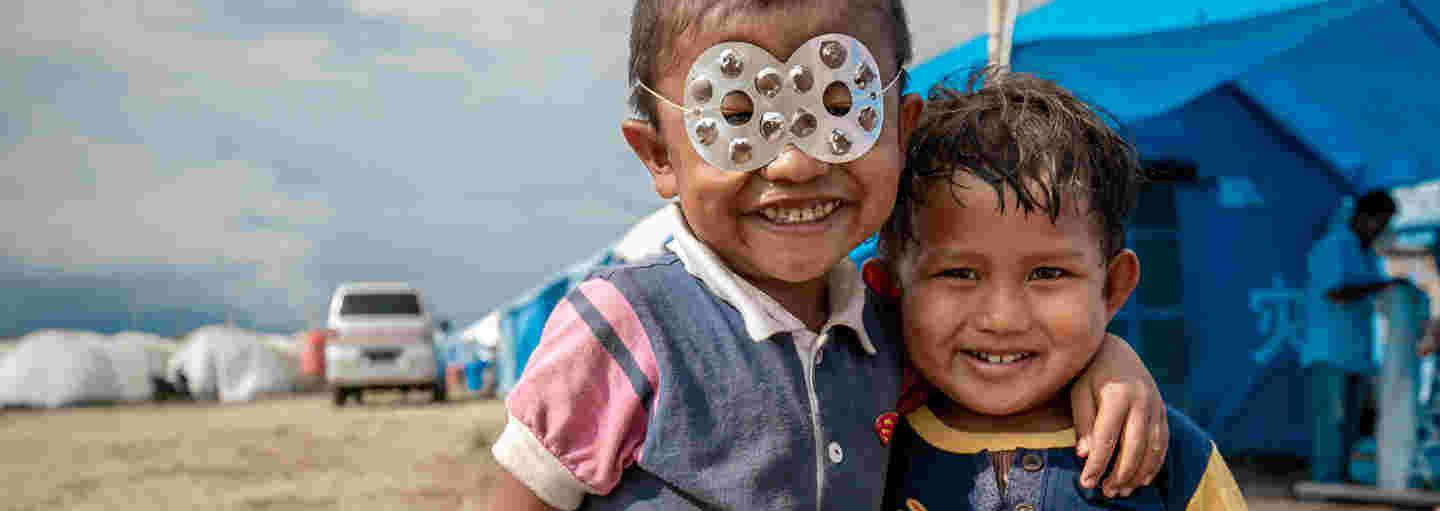 Children playing superheroes at a refugee camp.