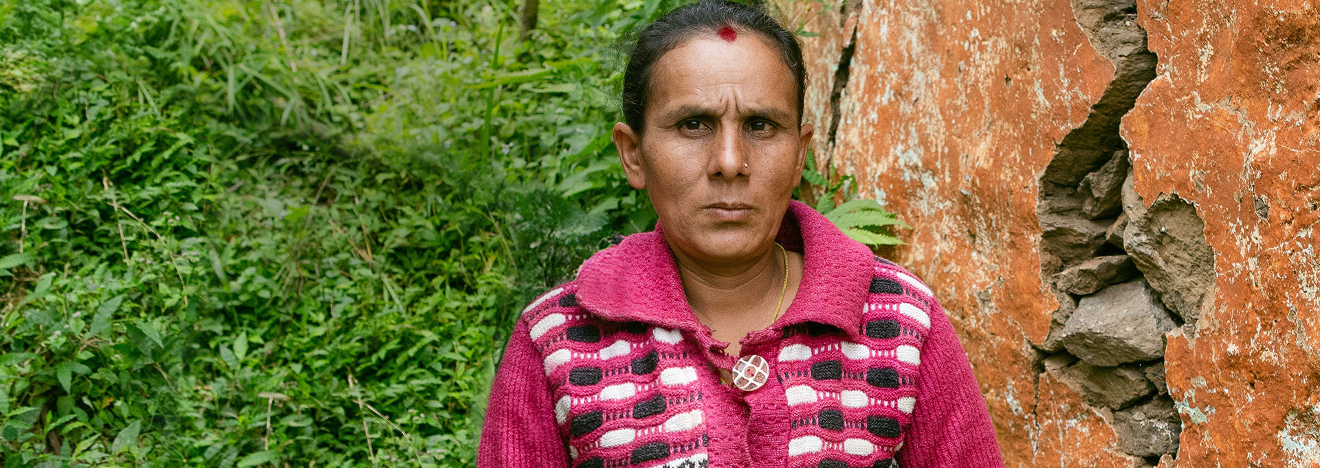 Two Red Cross volunteers in red vests, holding collection boxes. They are next to an about two-metre tall collection box.