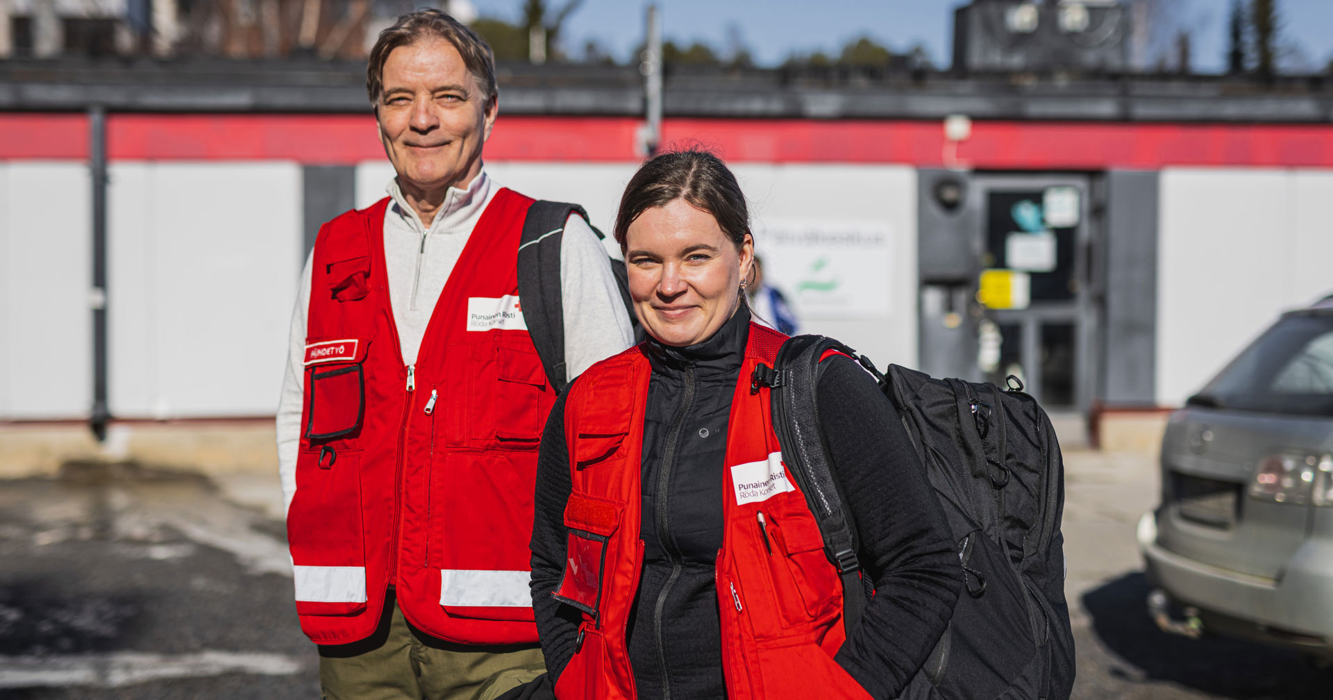 Kari and Petra smiling outdoors, wearing Red Cross clothes.