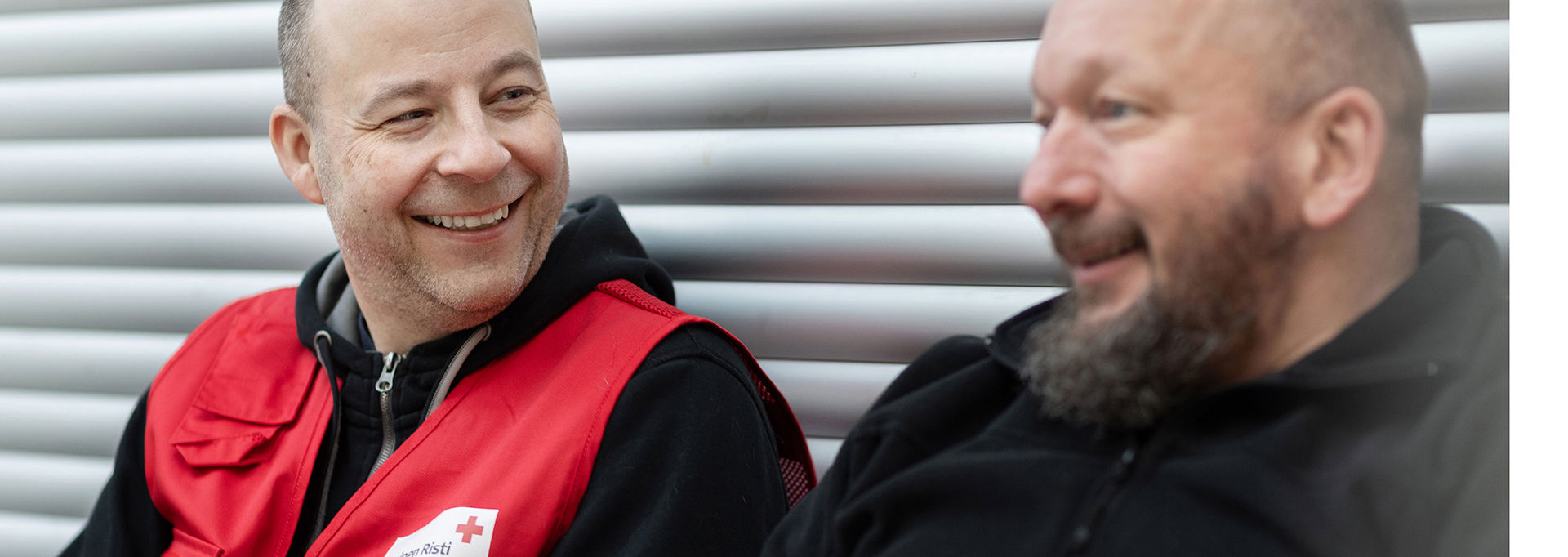 A Red Cross volunteer is discussing with another person.