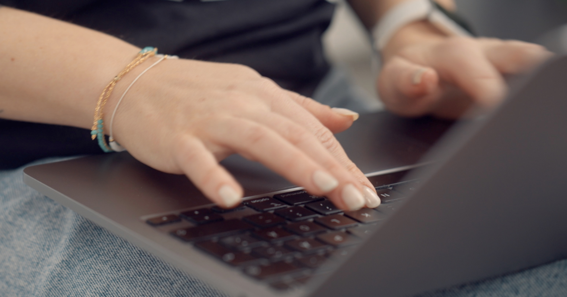 Hands typing on a laptop keyboard.