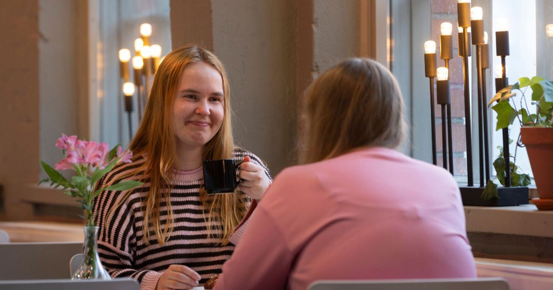 Two persons sitting in a cafe.