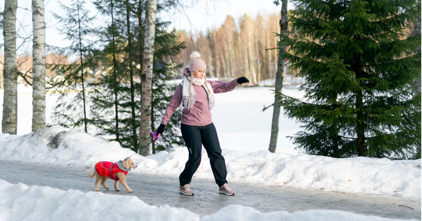 A woman and her dog walking on a slippery exercise route.