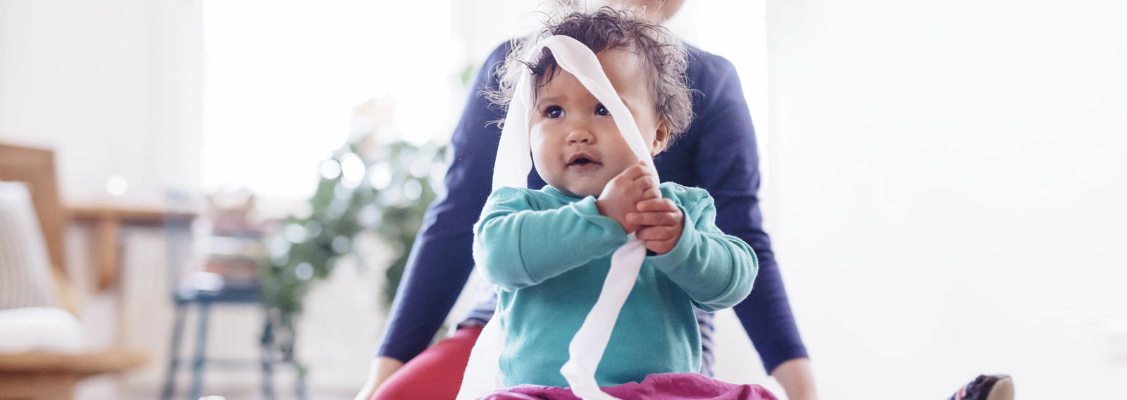 A small child playing with dressing gauze.