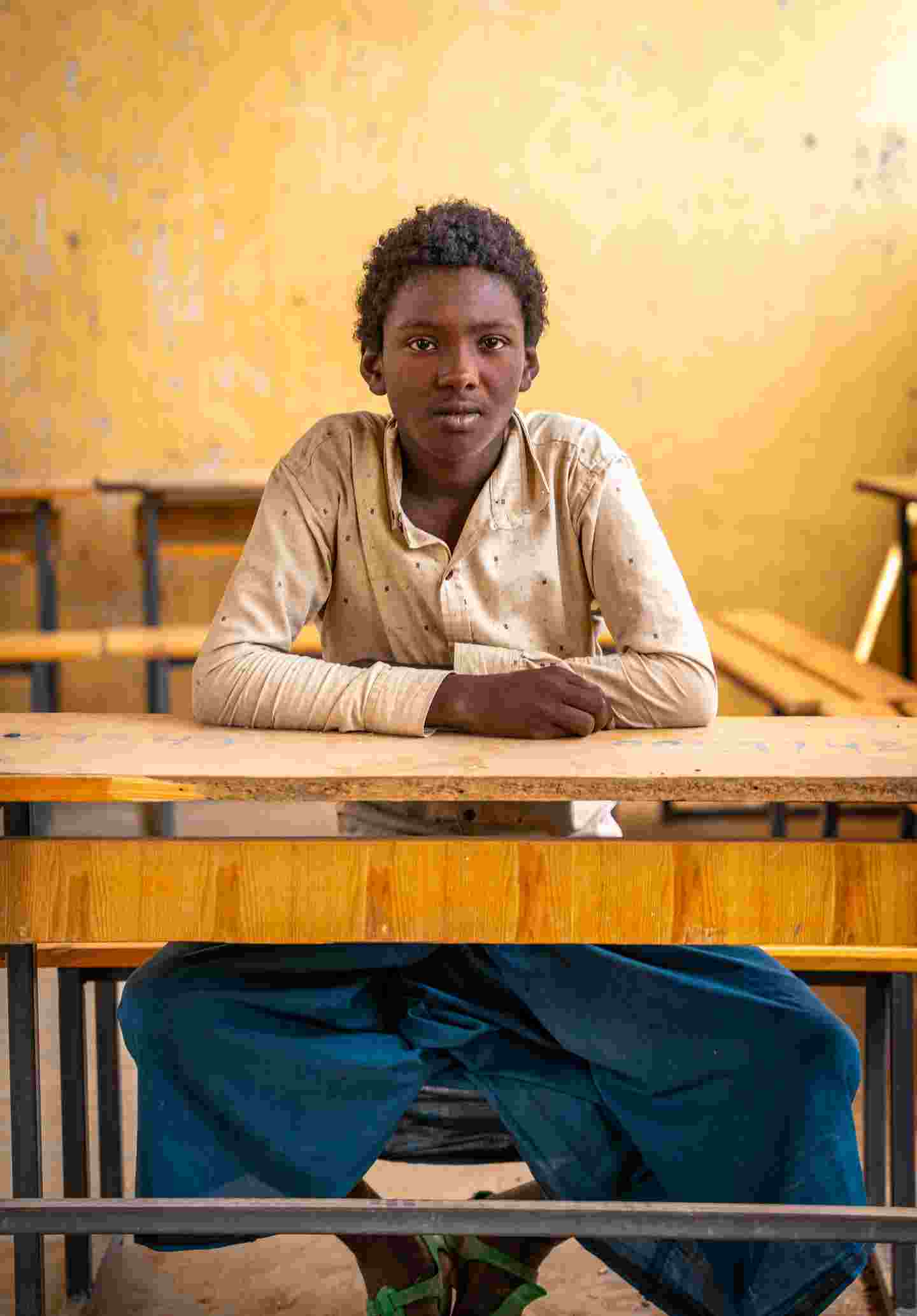 A young person sitting in a class room.