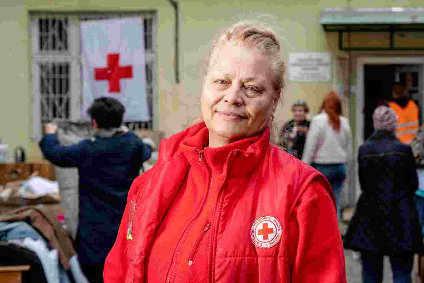 A woman wearing the Red Cross’ vest in medium close-up.