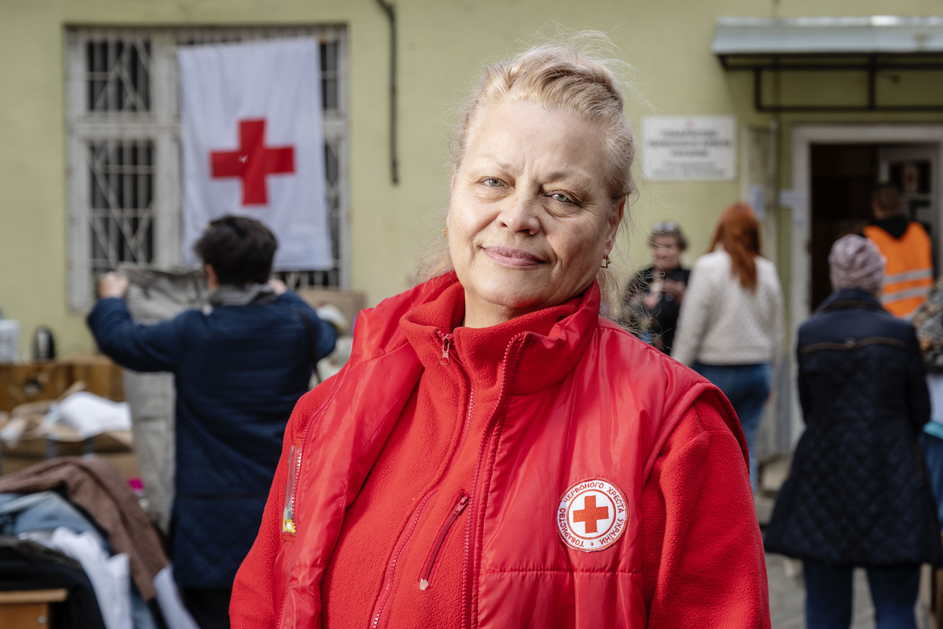A woman wearing the Red Cross’ vest in medium close-up.