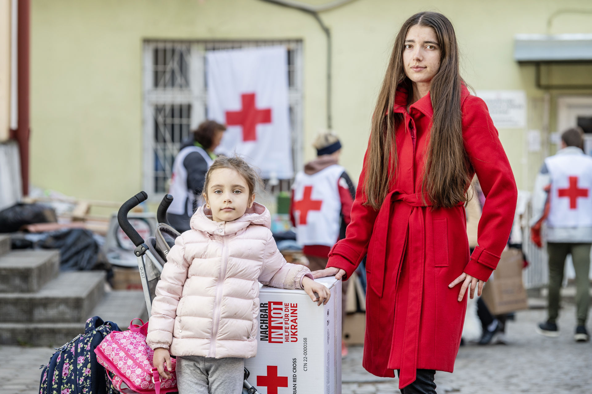 A mother and daughter standing next to each other.