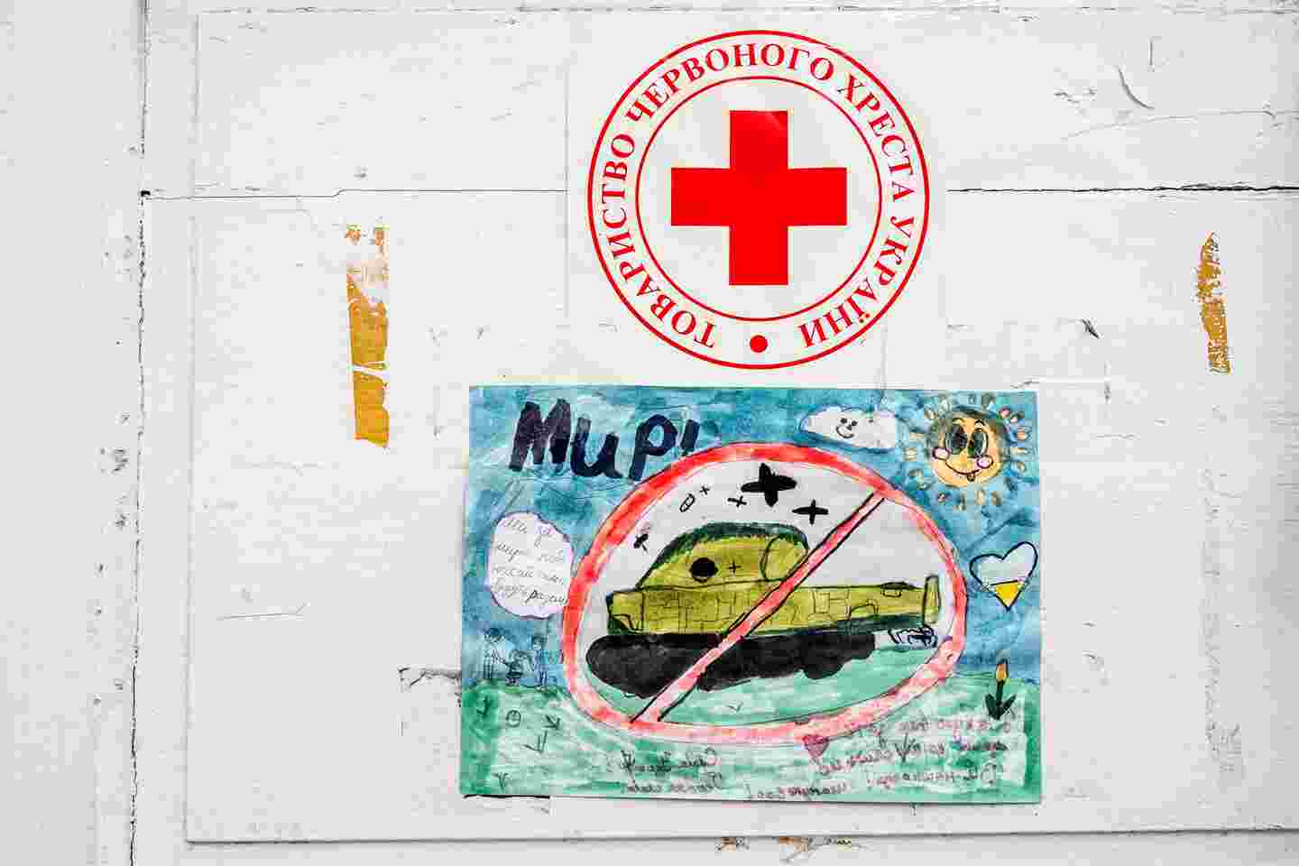 A child’s drawing of a tank. There is a Red Cross logo above the tank.