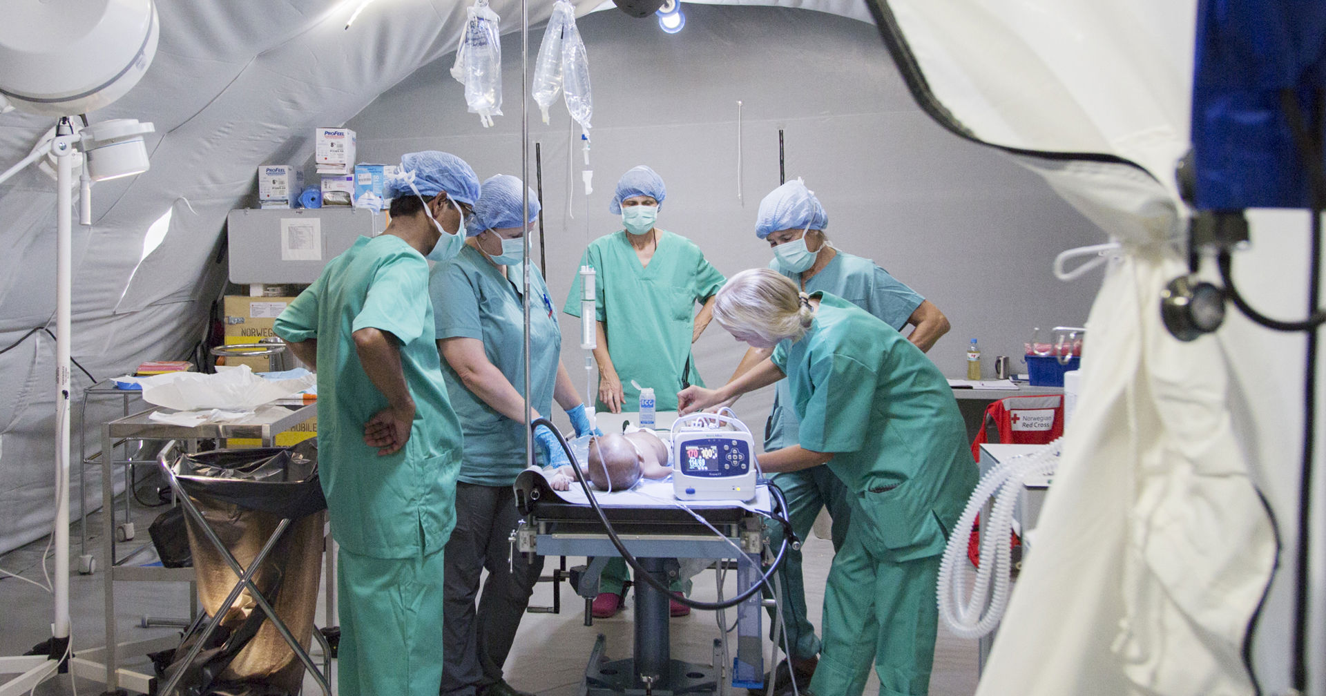 Red Cross aid workers perform a surgical procedure in a field hospital in Bangladesh