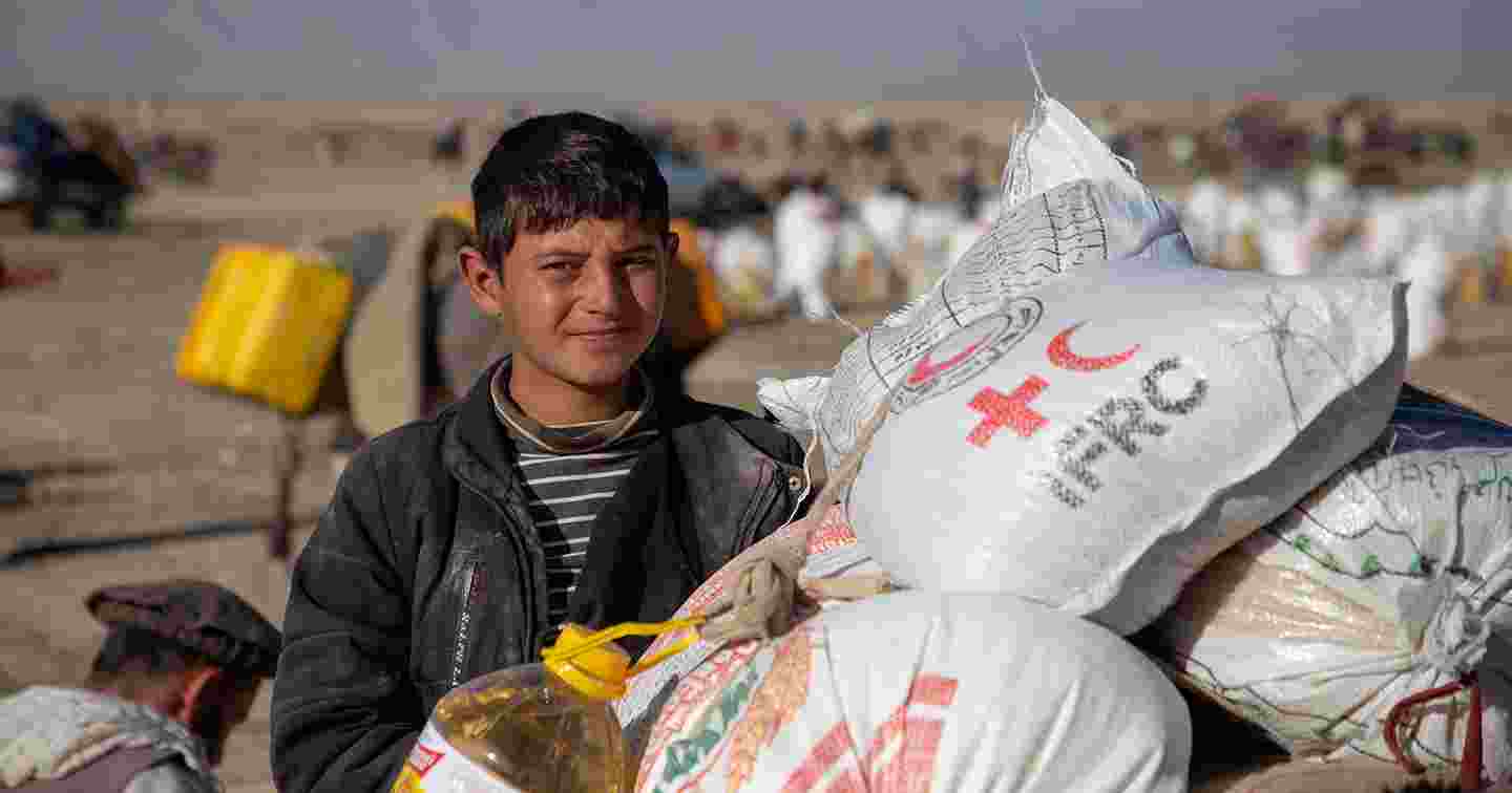 A young Afghan collecting Red Cross aid supplies.