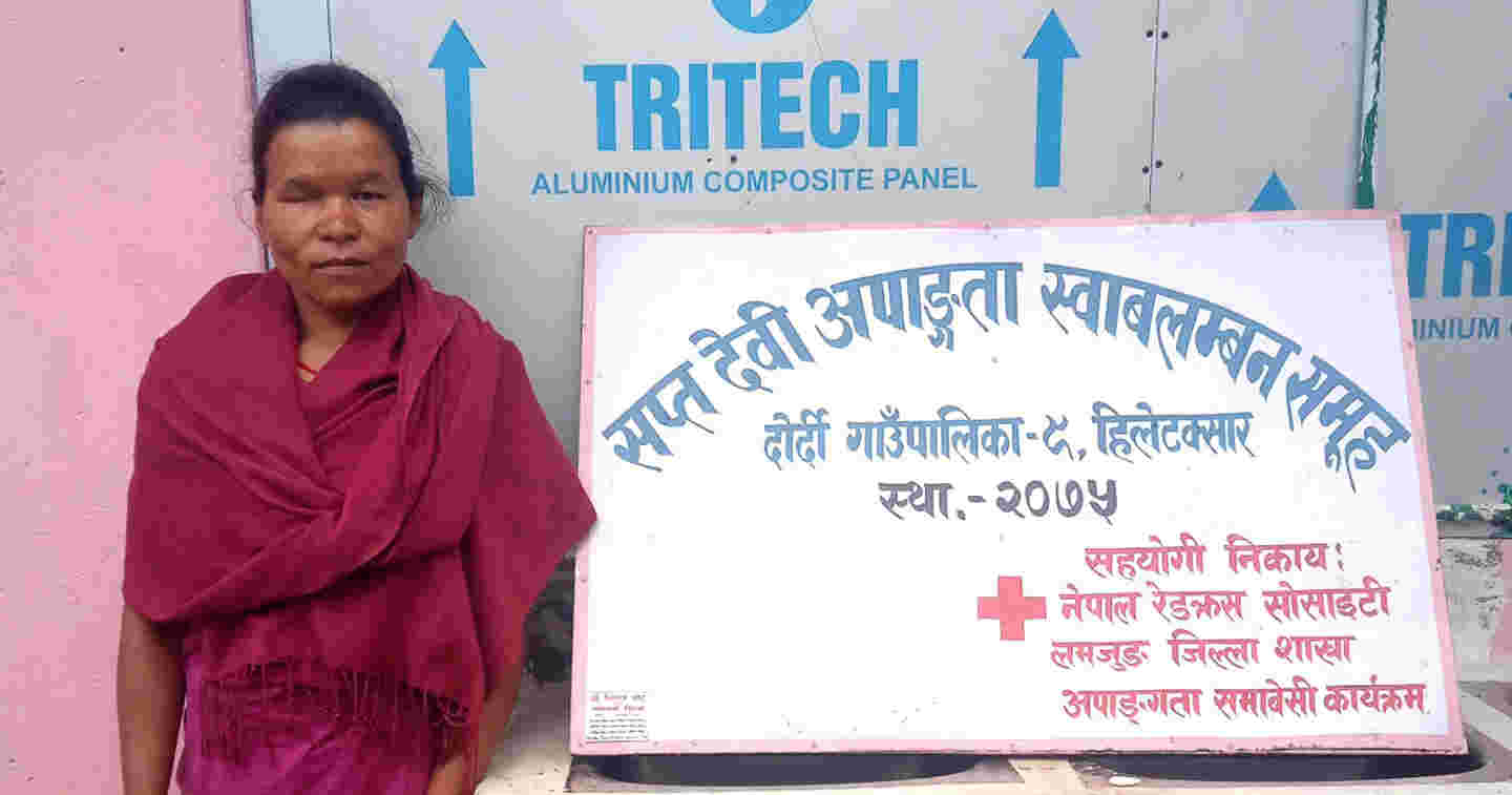 A woman standing in front of a sign.